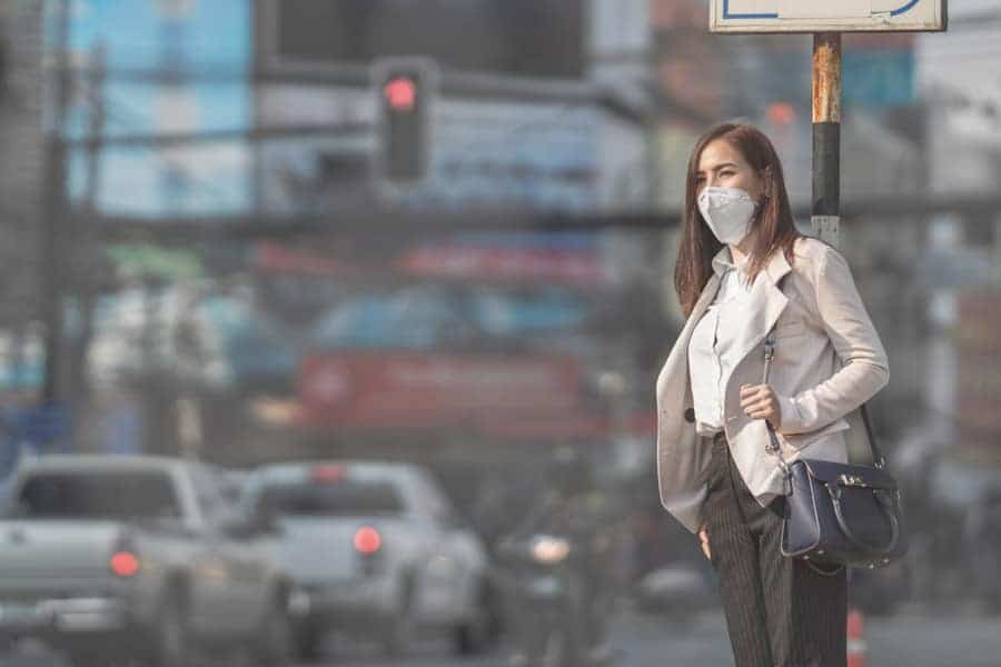 person on a busy street wearing a mask