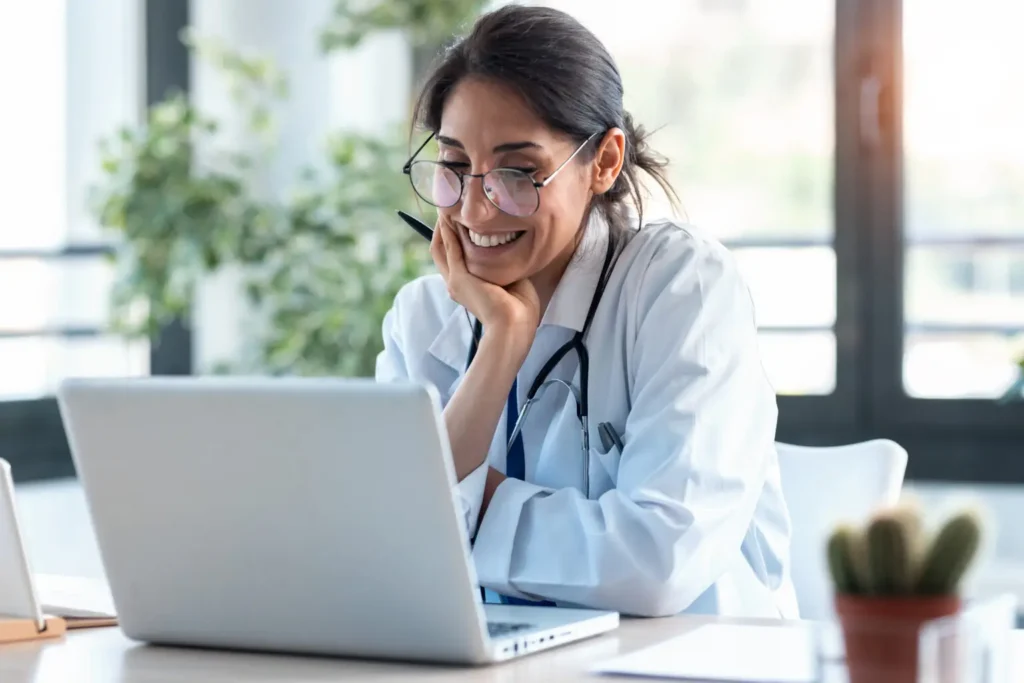 healthcare worker smiling at laptop