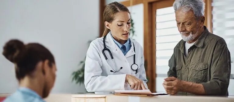 Healthcare professional talking to man in green shirt.