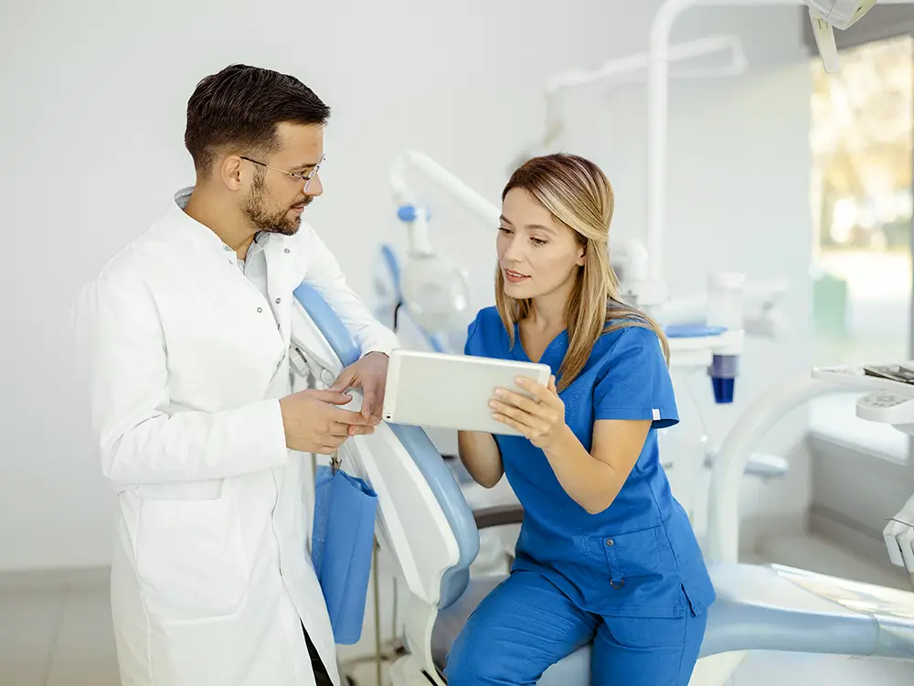 Dentist assistant showing dentist a tablet