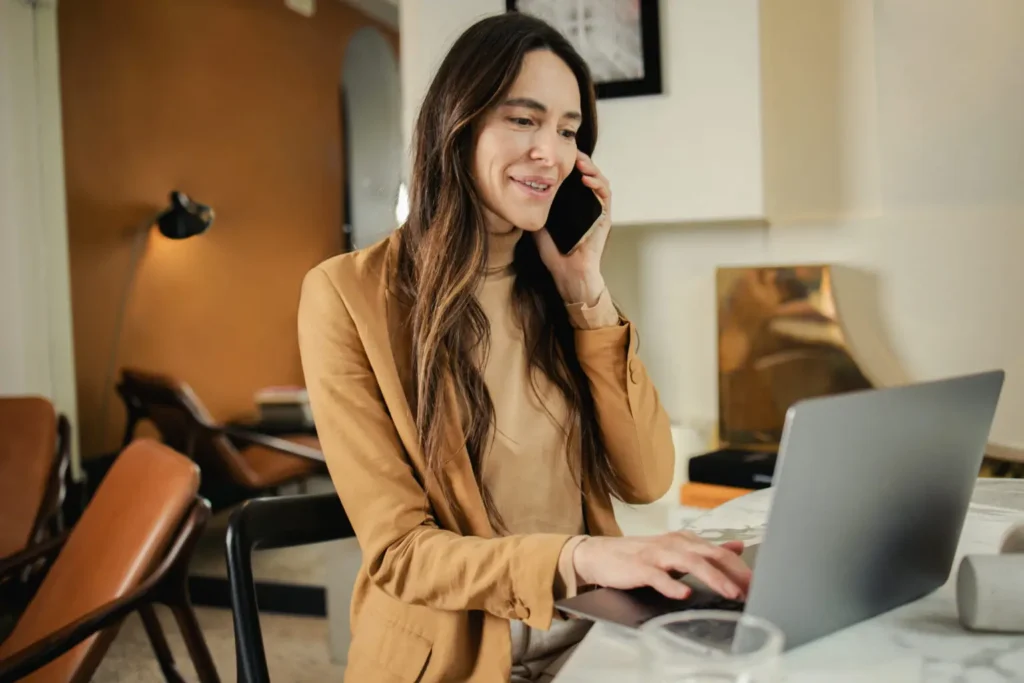 Woman on phone while using laptop