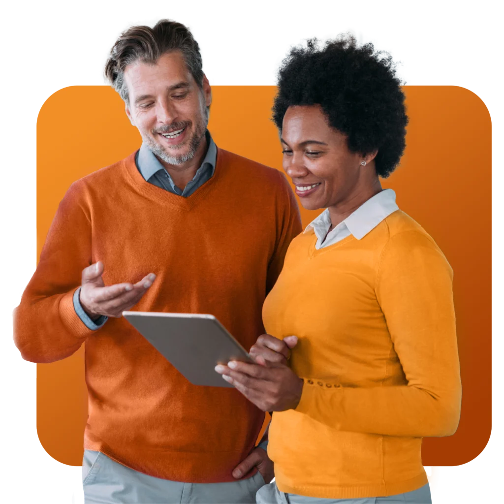 a man and a woman are looking at a tablet together