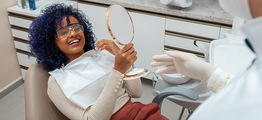 Woman looking in mirror at dentist