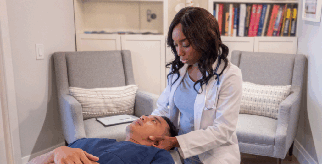 A chiropractor adjust a patient who is laying on a table in front of her